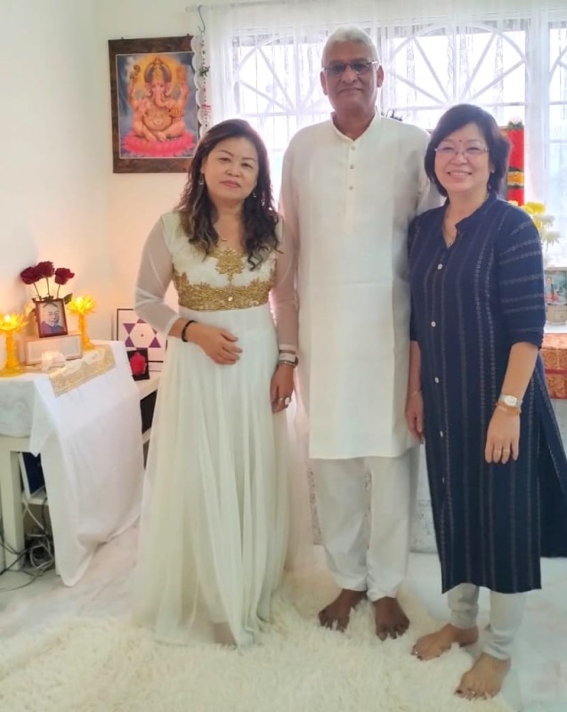 Jay Shiva with Reiki Master and Practitioner at Healing Center in Kuala Lumpur Jay Shiva standing with his Reiki master and a female Reiki practitioner in a warmly lit spiritual healing room in Kuala Lumpur, with an altar, portrait of Dr. Mikao Usui, and a Ganesha painting in the background.